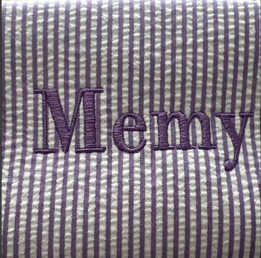 Detalle del nombre Memy bordado en lila sobre la cosmetiquera